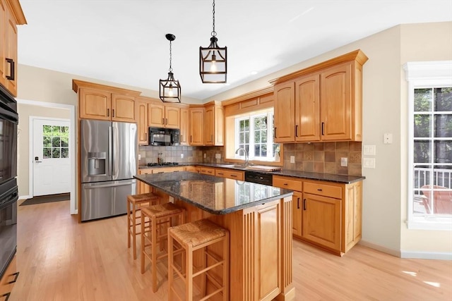 20 Ericka Cir, East Longmeadow, MA 01028 - kitchen featuring black appliances, light wood-type flooring, a kitchen breakfast bar, and decorative backsplash