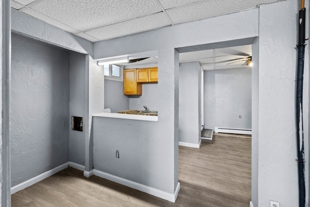 interior space featuring light hardwood / wood-style flooring, baseboard heating, and sink