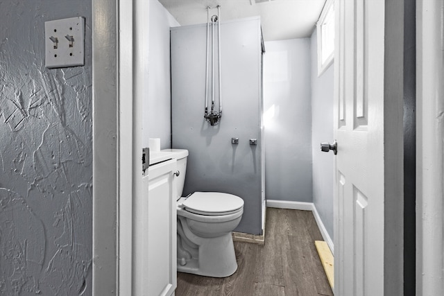 bathroom featuring hardwood / wood-style flooring and toilet