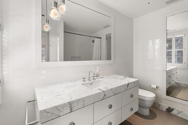 55 Fayerweather St, Cambridge, MA 02138 - bathroom with toilet, vanity, a shower with curtain, and tile walls