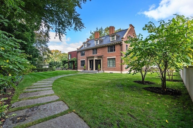 55 Fayerweather St, Cambridge, MA 02138 - back of house with brick siding, fence, a lawn, and a chimney