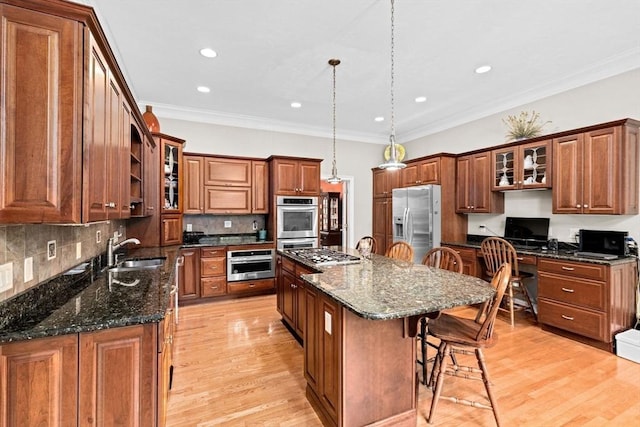15 Henrys Ln, Norwell, MA 02061 - kitchen with appliances with stainless steel finishes, a kitchen breakfast bar, a sink, a center island, and brown cabinetry