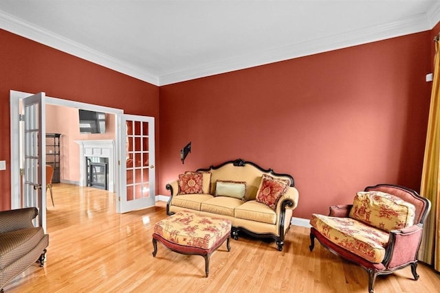 15 Henrys Ln, Norwell, MA 02061 - living room featuring french doors, wood finished floors, ornamental molding, baseboards, and a glass covered fireplace