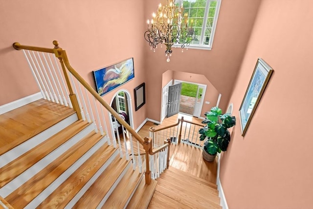 15 Henrys Ln, Norwell, MA 02061 - staircase featuring a chandelier, healthy amount of natural light, a towering ceiling, baseboards, and wood finished floors