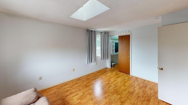 35 Prospect St Unit 309, Woburn, MA 01801 - unfurnished room featuring light wood finished floors, a skylight, and a textured ceiling