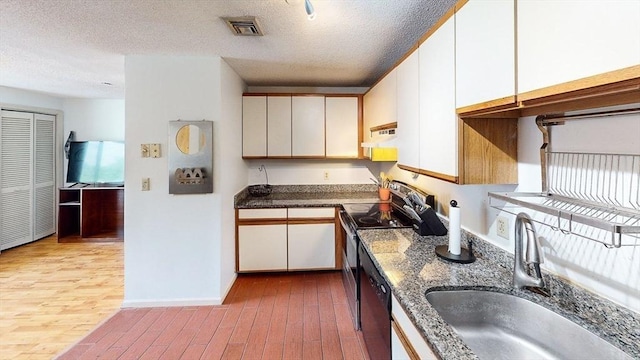 35 Prospect St Unit 309, Woburn, MA 01801 - kitchen with a sink, extractor fan, stainless steel electric stove, white cabinets, and wood finished floors