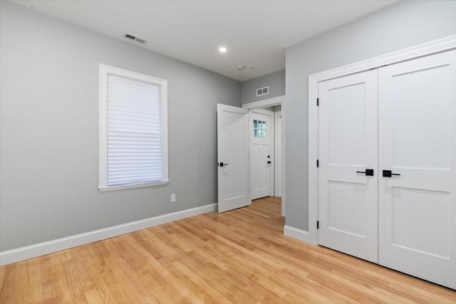 unfurnished bedroom with light wood-type flooring, baseboards, a closet, and recessed lighting