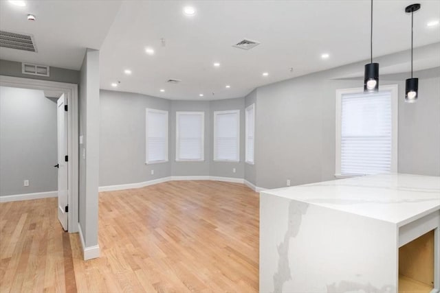 empty room featuring light wood-type flooring, baseboards, and recessed lighting