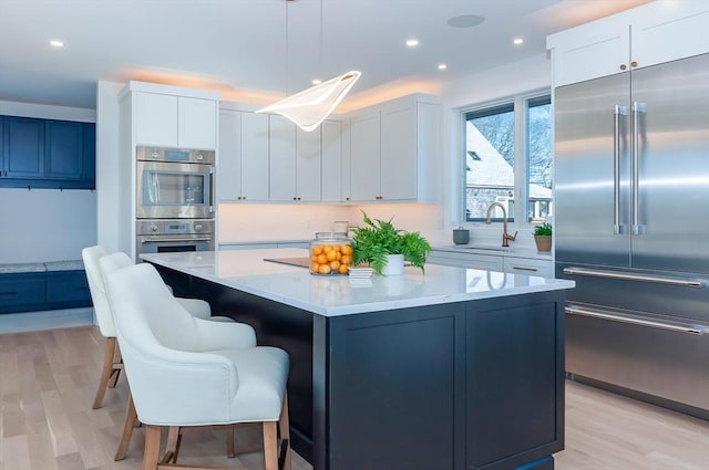 25 W Ave, Marion, MA 02738 - kitchen with a center island, light countertops, light wood-style flooring, and stainless steel appliances