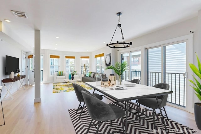 dining room with light hardwood / wood-style flooring and a notable chandelier