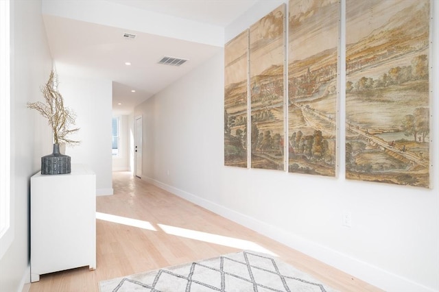 hallway featuring wood finished floors, baseboards, and recessed lighting