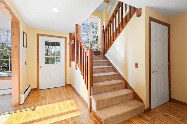 foyer entrance featuring a baseboard radiator and light wood-type flooring