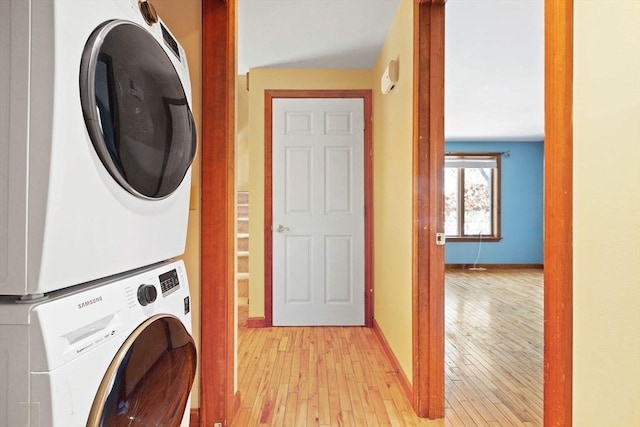 washroom featuring stacked washer / drying machine and light hardwood / wood-style floors