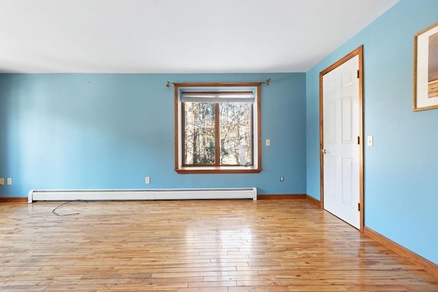 spare room featuring light wood-type flooring and baseboard heating