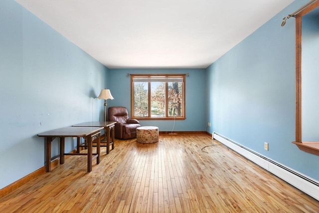 living area featuring a baseboard radiator and light hardwood / wood-style floors