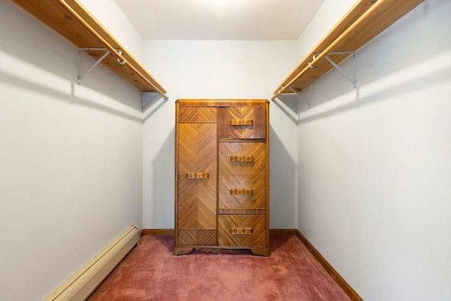 walk in closet with baseboard heating and dark carpet