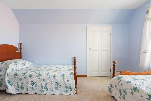 bedroom featuring lofted ceiling, a baseboard heating unit, and light colored carpet