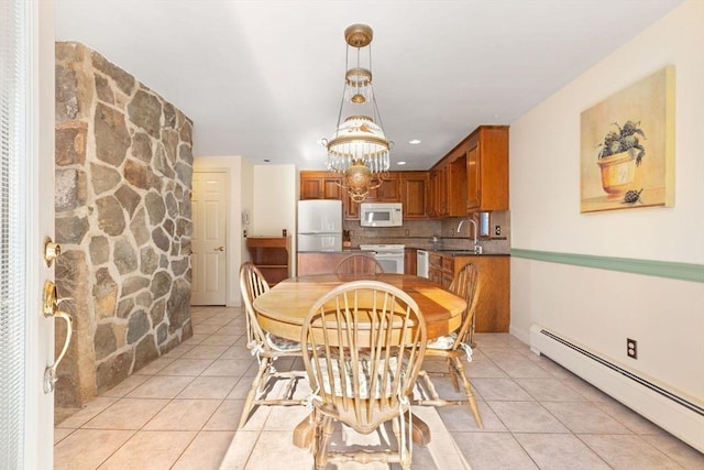 tiled dining area featuring sink and a baseboard heating unit