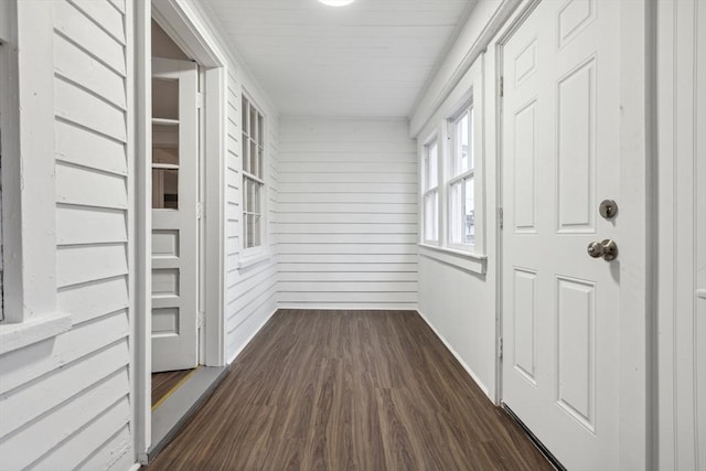 hallway with wood walls and dark hardwood / wood-style flooring