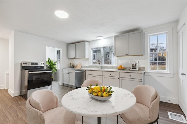 kitchen featuring sink, stainless steel appliances, dark wood-type flooring, and gray cabinets