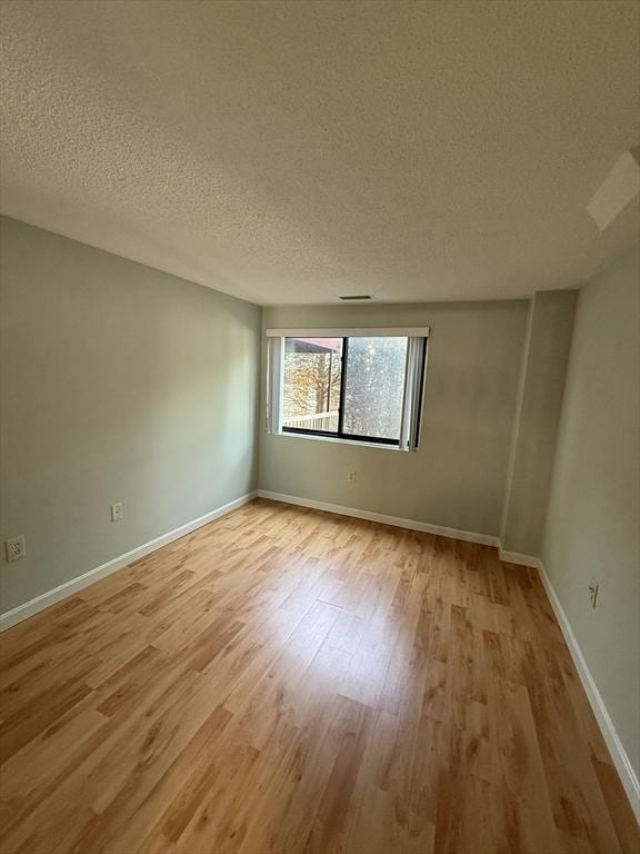 30 Revere Beach Pkwy Unit 116, Medford, MA 02155 - spare room featuring a textured ceiling, wood finished floors, and baseboards