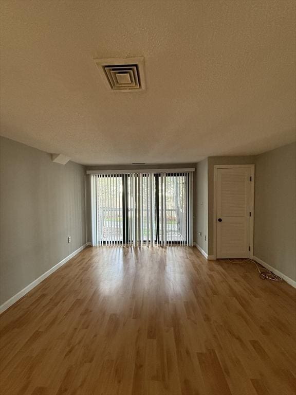 30 Revere Beach Pkwy Unit 116, Medford, MA 02155 - unfurnished room with baseboards, wood finished floors, and a textured ceiling