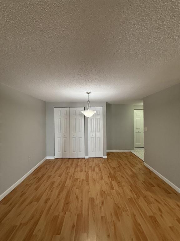 30 Revere Beach Pkwy Unit 116, Medford, MA 02155 - unfurnished dining area with baseboards, a textured ceiling, and light wood finished floors
