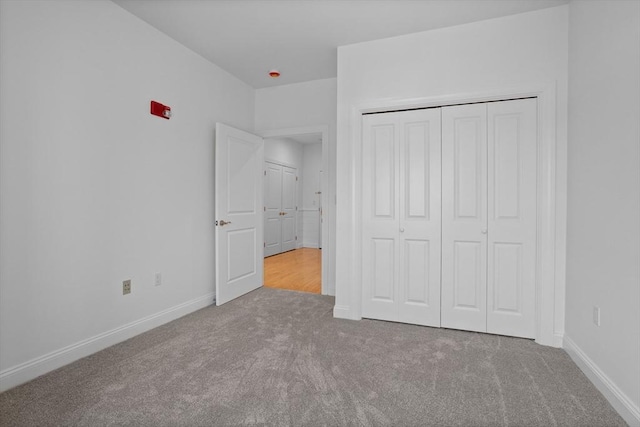 unfurnished bedroom with a closet and carpet flooring