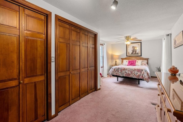 97 Connecticut Ave, Springfield, MA 01104 - bedroom with light colored carpet, a textured ceiling, two closets, and ceiling fan
