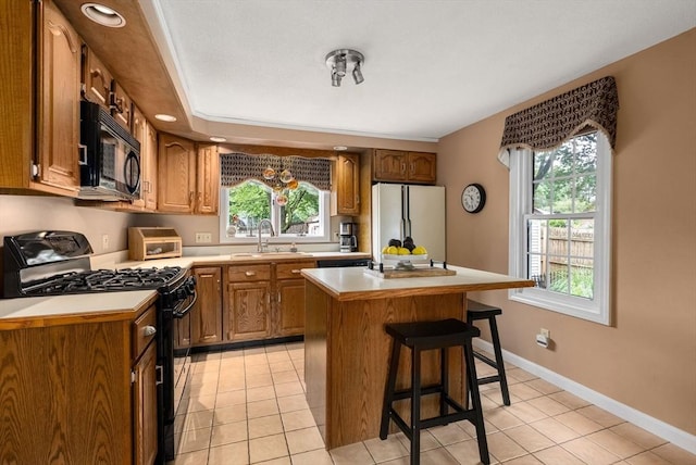 97 Connecticut Ave, Springfield, MA 01104 - kitchen featuring black appliances, a breakfast bar, healthy amount of natural light, and light countertops