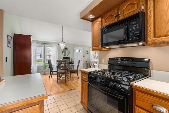 97 Connecticut Ave, Springfield, MA 01104 - kitchen with black appliances, light countertops, brown cabinets, light tile patterned flooring, and decorative light fixtures
