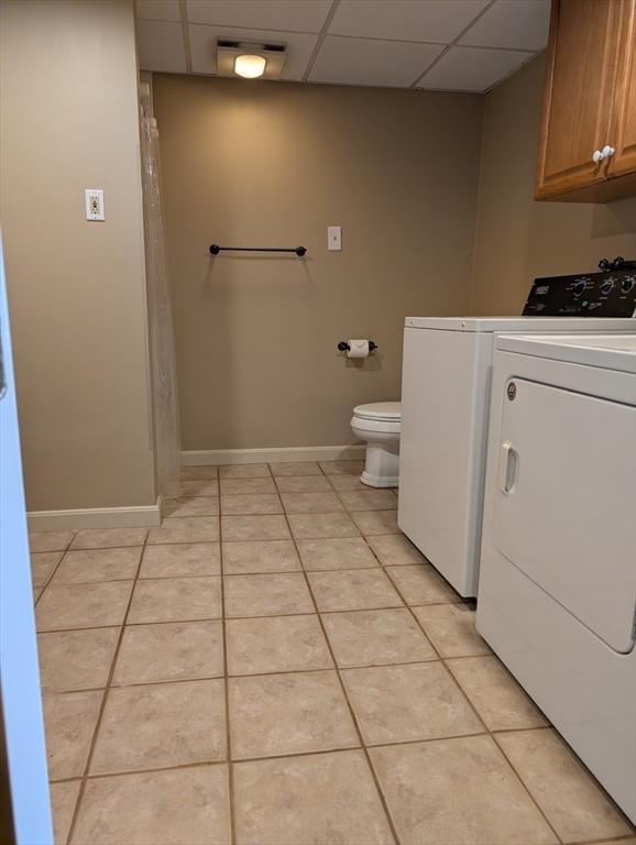 285 Still River Rd, Bolton, MA 01740 - bathroom featuring a paneled ceiling, tile patterned floors, toilet, baseboards, and washer and dryer