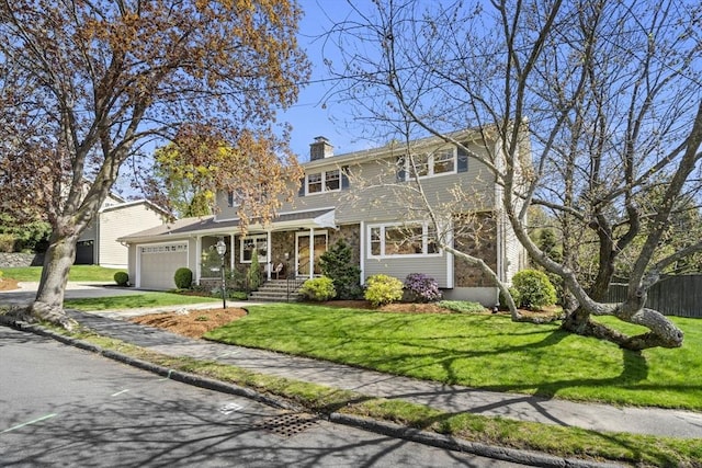 traditional-style home with an attached garage, fence, a chimney, concrete driveway, and a front yard
