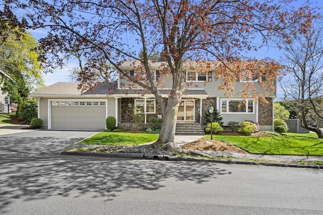traditional-style home featuring a front yard, a garage, and driveway