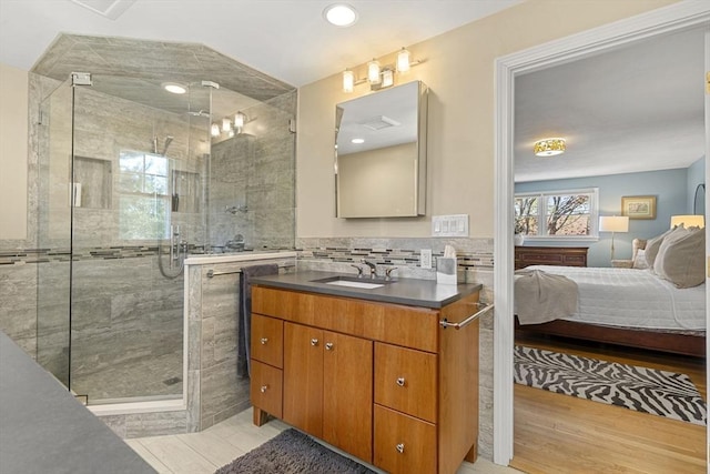 bathroom featuring a stall shower, vanity, ensuite bathroom, and wood finished floors