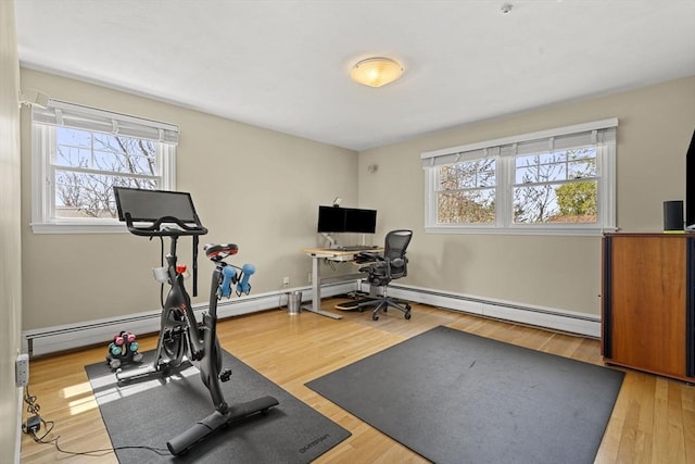 workout room with wood finished floors and a baseboard radiator
