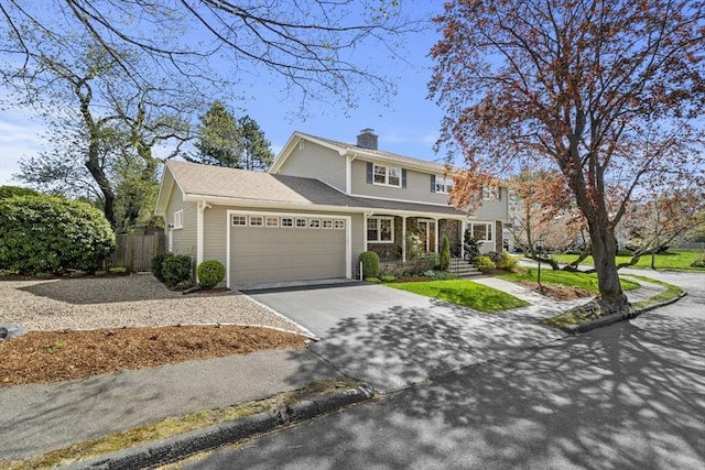 traditional home featuring a garage, a chimney, fence, aphalt driveway, and a porch