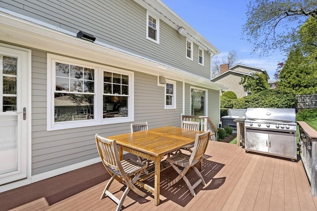 wooden terrace with area for grilling and outdoor dining space