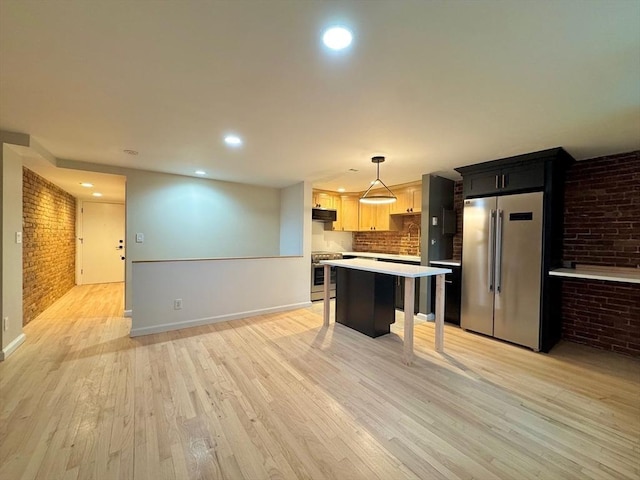 191 W Canton Unit 1, Boston, MA 02116 - kitchen with stainless steel appliances, brick wall, light countertops, baseboards, and light wood finished floors
