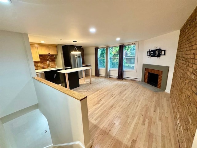 191 W Canton Unit 1, Boston, MA 02116 - kitchen featuring light countertops, light wood-style floors, recessed lighting, a brick fireplace, and a sink