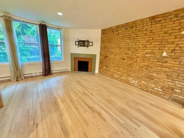 191 W Canton Unit 1, Boston, MA 02116 - unfurnished living room with brick wall, baseboard heating, wood finished floors, and a fireplace