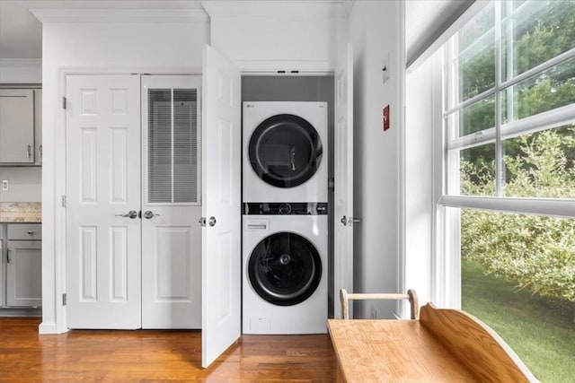 23 Brookstone Unit 23, Bridgewater, MA 02324 - laundry area with stacked washer / drying machine, ornamental molding, and wood finished floors