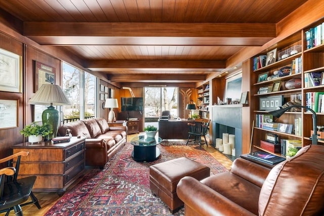 living area featuring wood ceiling, wood walls, a fireplace with flush hearth, and beam ceiling