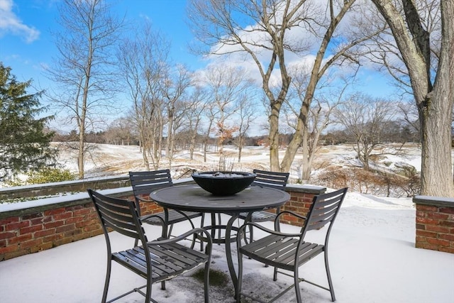 snow covered patio with outdoor dining space