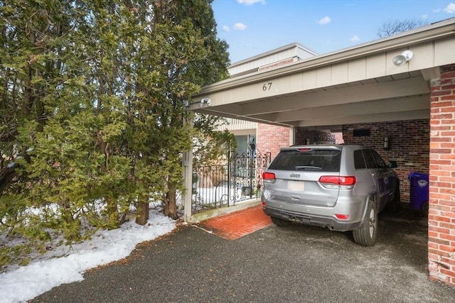 view of parking with a gate and fence