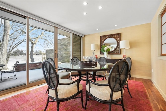 dining space with recessed lighting, expansive windows, baseboards, and wood finished floors