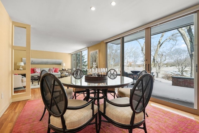 dining area with light wood-type flooring, floor to ceiling windows, and recessed lighting