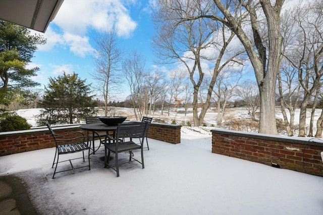 snow covered patio featuring outdoor dining space