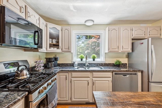 2 Strawstone Ln, Norton, MA 02766 - kitchen with stainless steel appliances, a sink, glass insert cabinets, and dark stone countertops