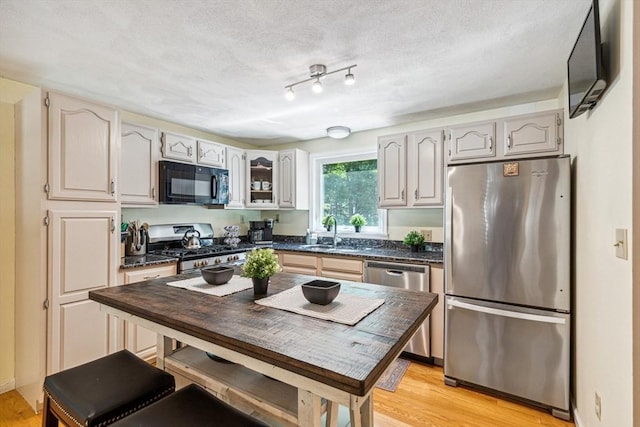 2 Strawstone Ln, Norton, MA 02766 - kitchen with appliances with stainless steel finishes, a sink, dark countertops, and light wood-type flooring